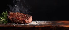 Barbecue dry aged wagyu entrecote beef steak roast with lettuce and salt as closeup on a charred wooden board. Copy space image. Place for adding text or design