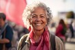 © Nerea - Portrait of a smiling senior woman with a red scarf in the street