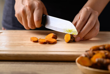 Wall Mural - Fresh turmeric cutting on wooden board prepare for Asian cuisine cooking