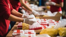 Close-up Of Hands Assembling Care Packages For Survivors Of Natural Disasters, Highlighting The Importance Of Disaster Relief Efforts