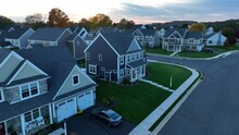 New neighborhood in USA suburb. Aerial shot of large, modern houses and homes during sunset in autumn.