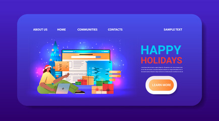 Wall Mural - web developer woman in santa hat creating program code on laptop screen development of software and 