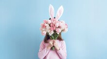 Surprised Little Girl With Bunny Ears And Flowers On Color Background. Easter Celebration