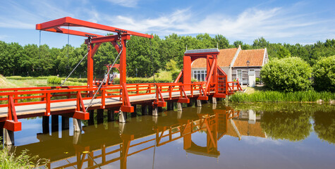 Wall Mural - Panorama of a red wooden bridge in historic village Bourtange, Netherlands