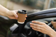 Woman buying takeaway coffee sitting in her car