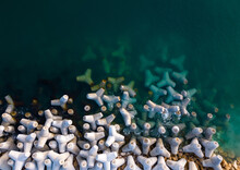 Aerial Drone View Of A Breakwater. Breakwater In The Sea, A Collection Of Concrete Tetrapod Breakers