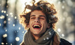 Joyful Young Man with Curly Hair Laughing and Enjoying Snowflakes in Sunlit Winter Wonderland