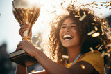 Fototapeta  - Beautiful female athlete holding her trophy after winning a competition. Young woman celebrating the victory under glittery confetti.