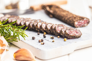 Wall Mural - Smoked dried sausage. Sliced sausage on cutting board.