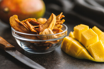 Sticker - Dried mango fruit in bowl on black table.