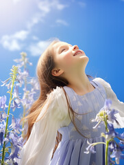 Wall Mural - A beautiful little girl in a bluebell flowers field against a blue sky