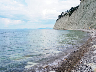 picturesque view from the shore to the cliff and the sea in summer