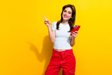 Canvas Print - Photo of intelligent woman dressed white t-shirt indicating at promo empty space hold smartphone isolated on yellow color background