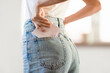 © Prostock-studio - Closeup of lady putting menstrual pad in jeans pocket indoor