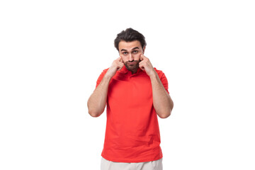 Wall Mural - young brutal caucasian brunette man with a beard dressed in red clothes on a studio background with copy space