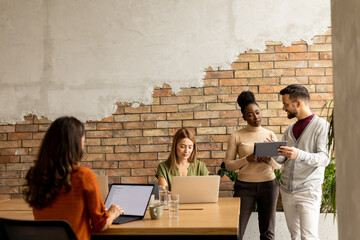 Poster - Young multiethnic startup team working in the rustic office