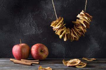 Wall Mural - Homemade dried apples with cinnamon, apple chips on a wooden background. Delicious healthy snack