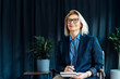 © okrasiuk - Portrait of smiling 50's stylish, confident mature businesswoman, middle aged company ceo director, experienced senior female professional, business coach team leader in modern office. Female leader