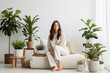 Happy young woman with a smile meditates among indoor plants at home. Mental health, Home gardening