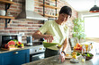 © Marko Geber - Young woman pouring healthy smoothie in glass bottle at home