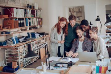 Wall Mural - Young and diverse group of architects working on a project together in a startup company office