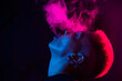 © Михаил Решетников - Profile Asian woman with short haircut smoking in neon light.
