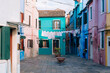 The daily life of Burano, Venice is captured with lines of laundry stretched between the colorful houses of the island