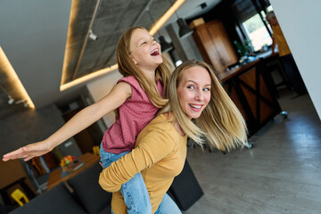 Wall Mural - mother child daughter fun family woman girl happy together happiness teenager piggyback cheerful togetherness bonding parent love young joy