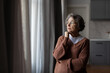 © Home-stock - Retirement and depression. Upset thoughtful senior woman standing and looking at window at home, free space