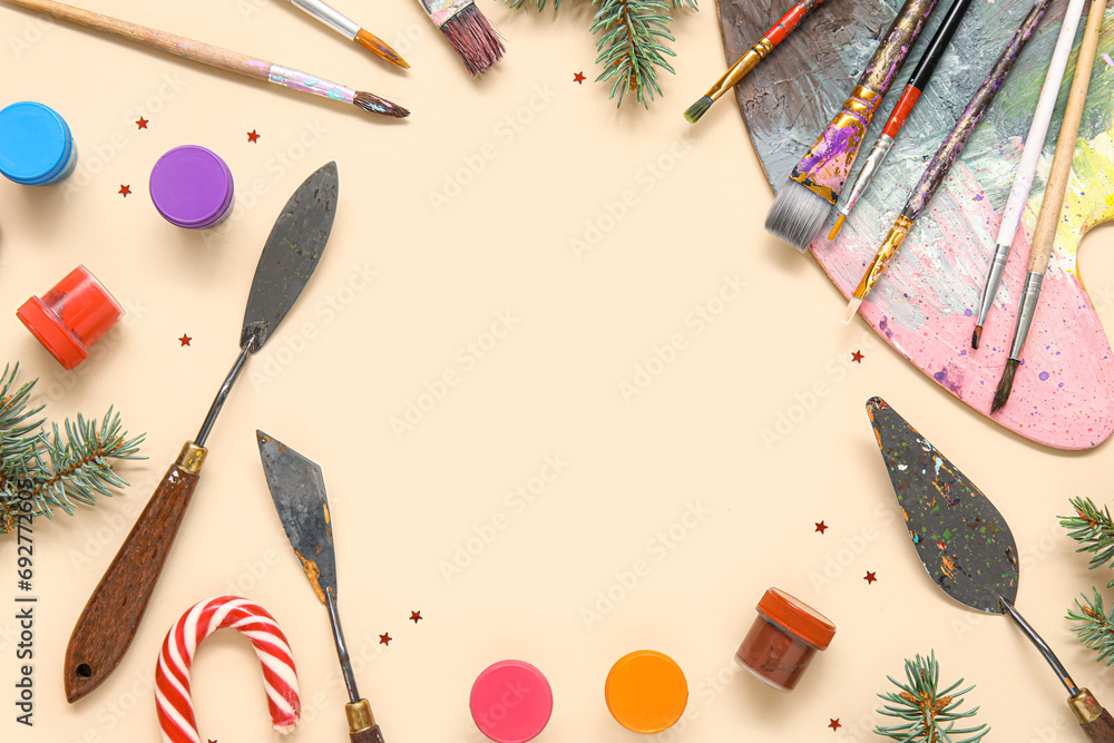 Frame made of painter's tools and fir branches on color background
