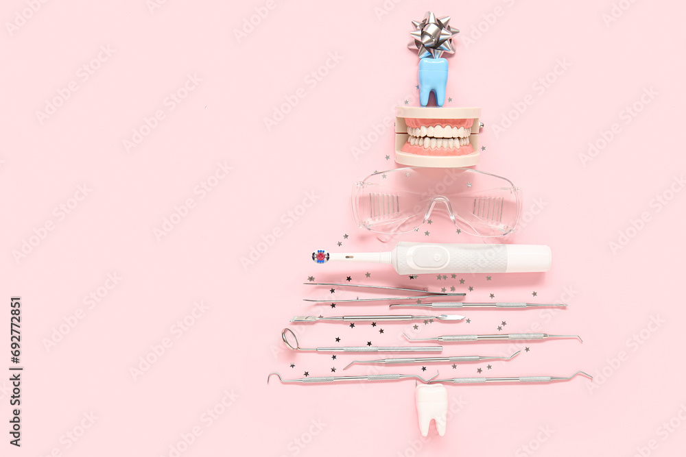 Christmas tree made of dentist's tools on pink background