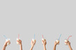 © Pixel-Shot - Hands holding glasses of milk with straws on grey background
