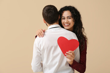 Sticker - Young couple with red heart for Valentine's day on beige background