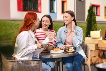 Canvas Print - Happy friends talking and drinking coffee in outdoor cafe