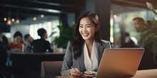 Portrait Of Happy Asian Businesswoman Working On Laptop In Cafe