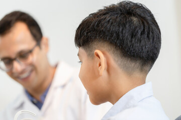 Wall Mural - Indian child choosing eyeglasses in optics store, Boy doing eye test checking examination with optometrist in optical shop, Optometrist doing sight testing for child patient in clinic