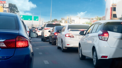 Wall Mural - Transport of car on the asphalt road. Rear side of blue car with turn on brake light. Many cars parking in a long queue in the city.