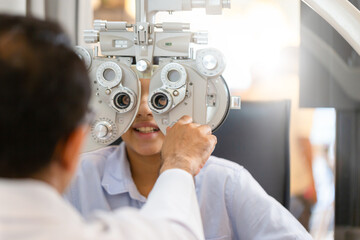 Wall Mural - Optometrist doing sight testing for child patient in clinic, Indian child choosing eyeglasses in optics store, Boy doing eye test checking examination with optometrist in optical shop