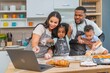 © BESTIMAGE - african afro black daughter kids with dad father and mom enjoy cooking class family funny internet learning by laptop . Black african family afro hair look computer for learn cooking in the kitchen