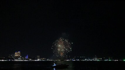 Wall Mural - Celebration. Skyline with fireworks light up sky over landmark skyscraper on the sea in Pattaya International Fireworks Festival, Thailand. Holidays, celebrating New year and tet holiday