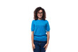 © Ivan Traimak - friendly young curly brunette woman in blue t-shirt on white background