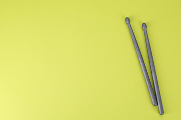 Wall Mural - Two gray drum sticks on light green background, top view. Space for text