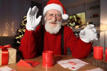 Sticker - Laughing Santa Claus at his workplace. Letters and cup of hot beverage on table in room decorated for Christmas