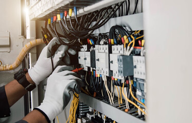 Wall Mural - Electrician engineer tests electrical installations and wires on relay protection system.