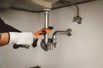 plumber at work in a bathroom, plumbing repair service , fix water plumbing leaks, replace the kitchen sink drain