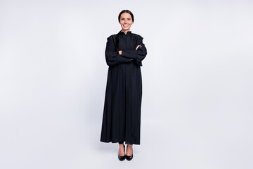 Poster - Full size photo of happy good mood positive woman judge with folded hands in black robe isolated on white color background