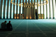 Islamic background photo. Two men praying in a modern mosque.