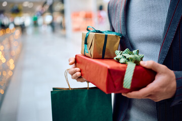 Wall Mural - Close up of man with wrapped presents at shopping mall.