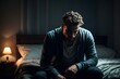 © New generate - depressed young man sitting head in hands on the bed in the dark bedroom with low light environment, dramatic concept