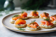 Delicious canapes with smoked salmon and dill on the plate close up